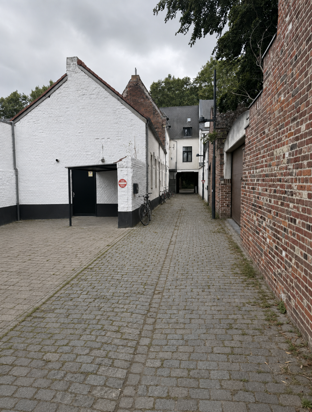 A quiet cobblestone alley near Verbrande Poort, Leuven